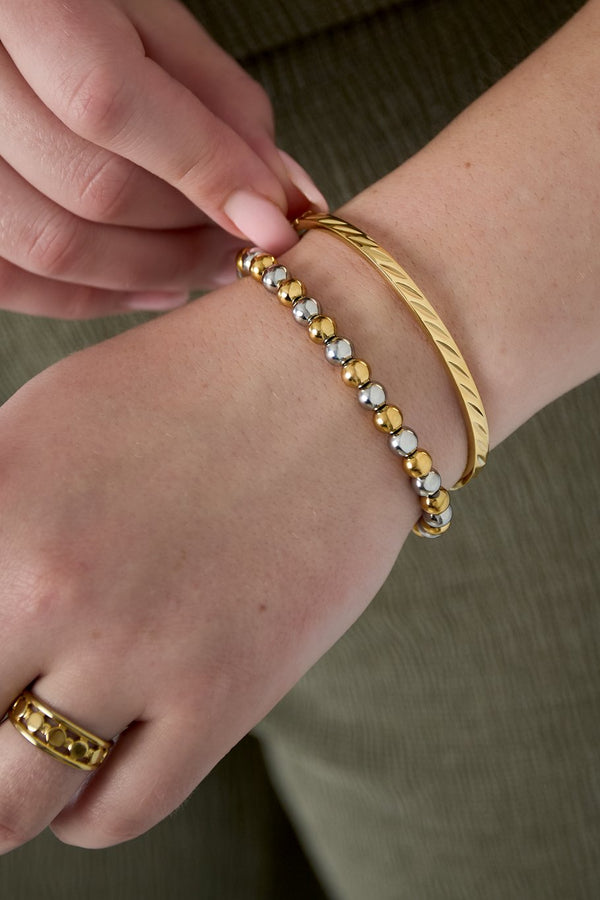 model draagt stainless steel bangle armband met reliëf Mara Jewellery