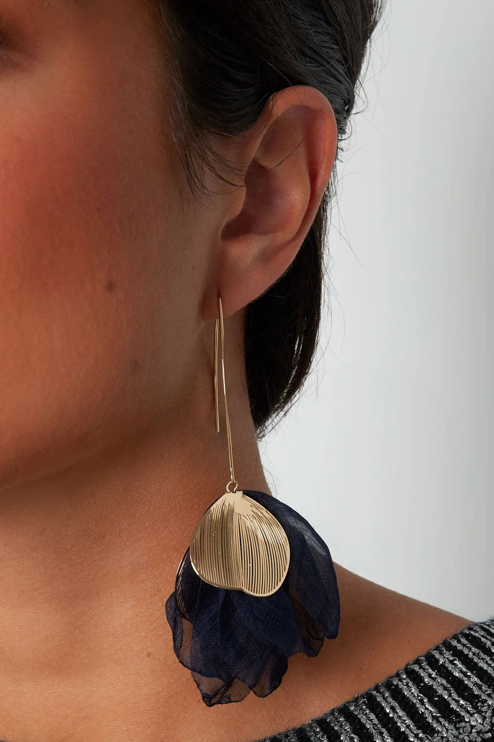 model draagt stainless steel oorbellen met bloemvorm Mara Jewellery