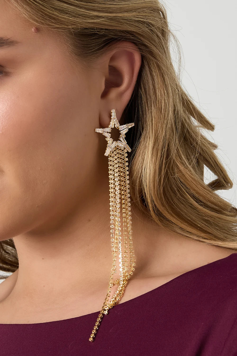model draagt stainless steel oorbellen met ster en lange kettingen Mara Jewellery